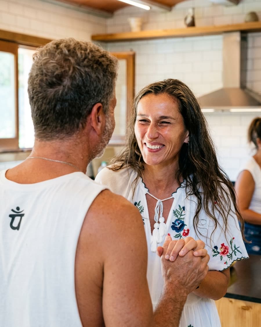 Two participants holding hands and smiling in the kitchen
